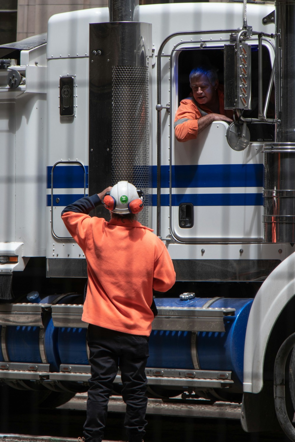 A trucking business owner standing in front of his truck